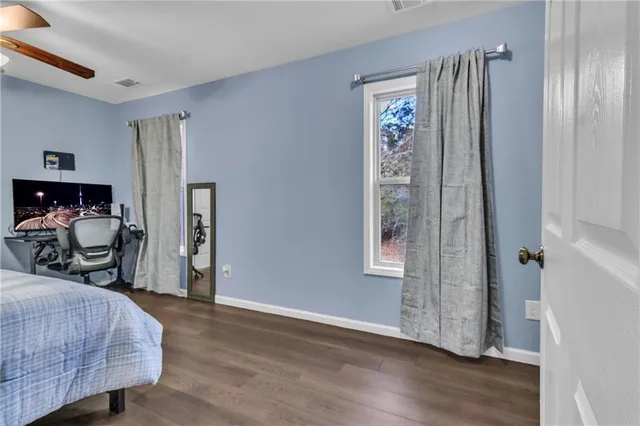 a bedroom with a large bed and a lamp on dresser