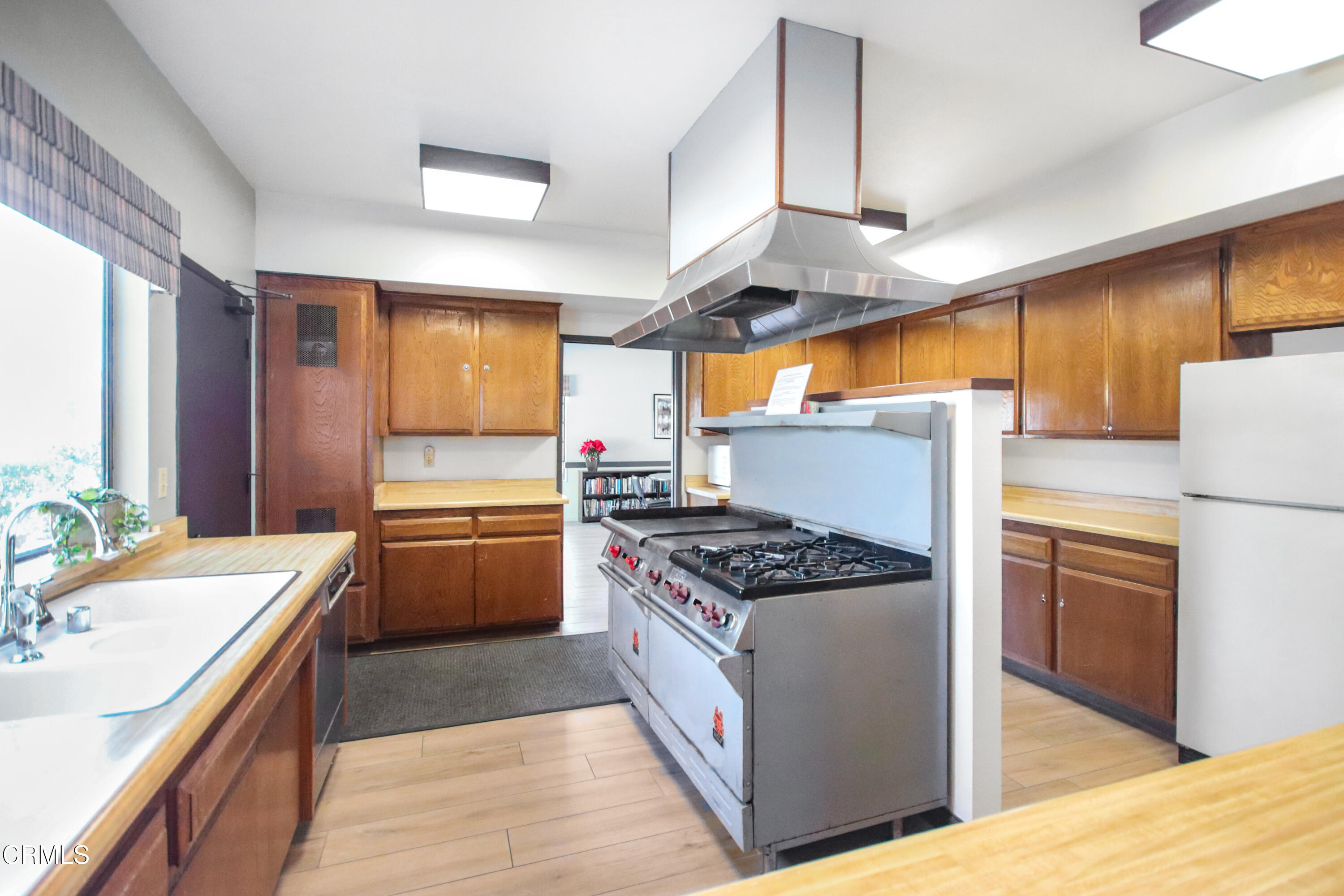 440 Dewberry Lane, Unit 105 Oxnard, CA 93036 - Photo 38 of 75 a kitchen with stainless steel appliances a sink a stove and a wooden floors