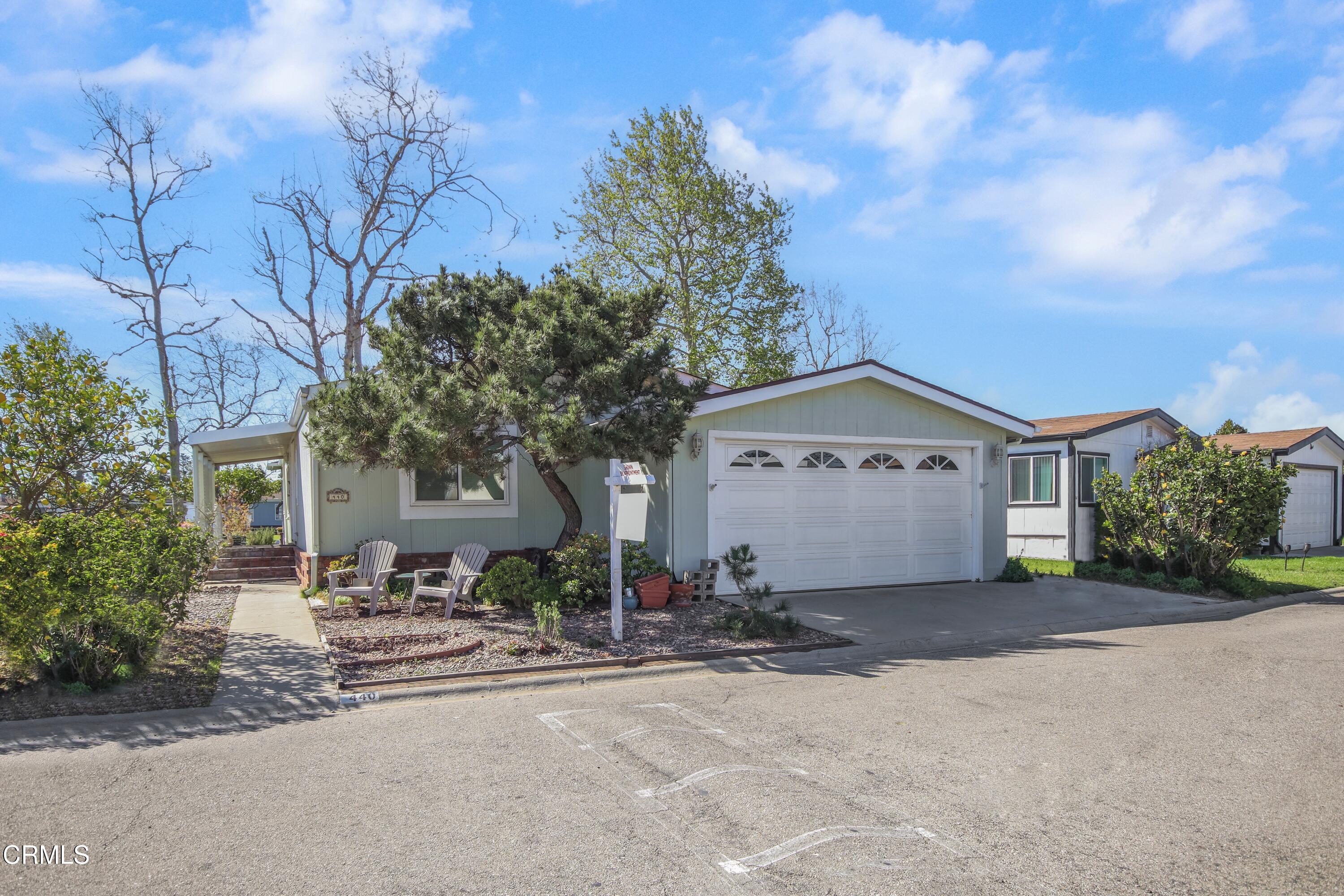 440 Dewberry Lane, Unit 105 Oxnard, CA 93036 - Photo 4 of 75 a front view of a house with a yard and garage