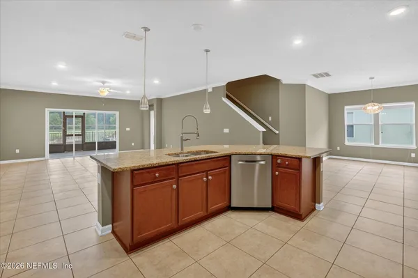 a large kitchen with stainless steel appliances granite countertop a sink and a cabinets