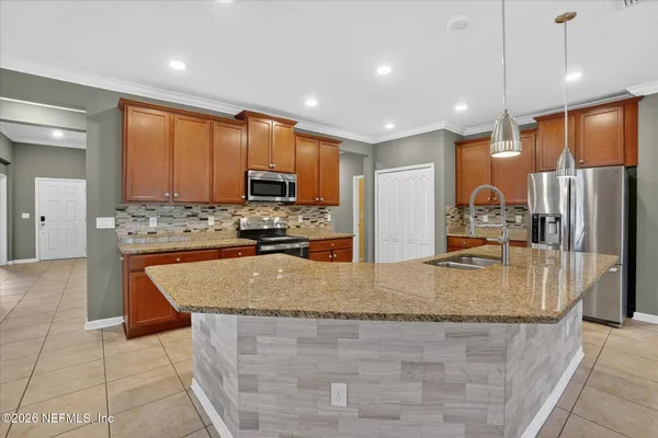 a large kitchen with kitchen island granite countertop a large counter top stainless steel appliances and cabinets