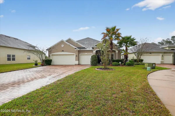 a front view of a house with a garden and plants