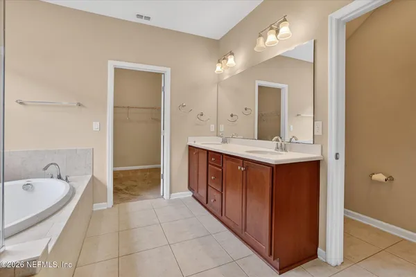 a bathroom with a tub a mirror and a shower