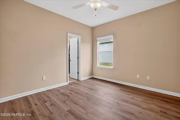 a view of an empty room with wooden floor