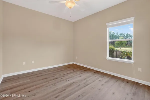 an empty room with windows and fan