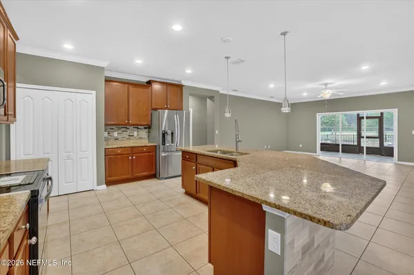 a kitchen with kitchen island granite countertop a stove a sink a counter space and cabinets