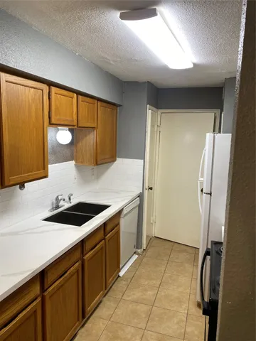 a kitchen with a sink a stove and cabinets