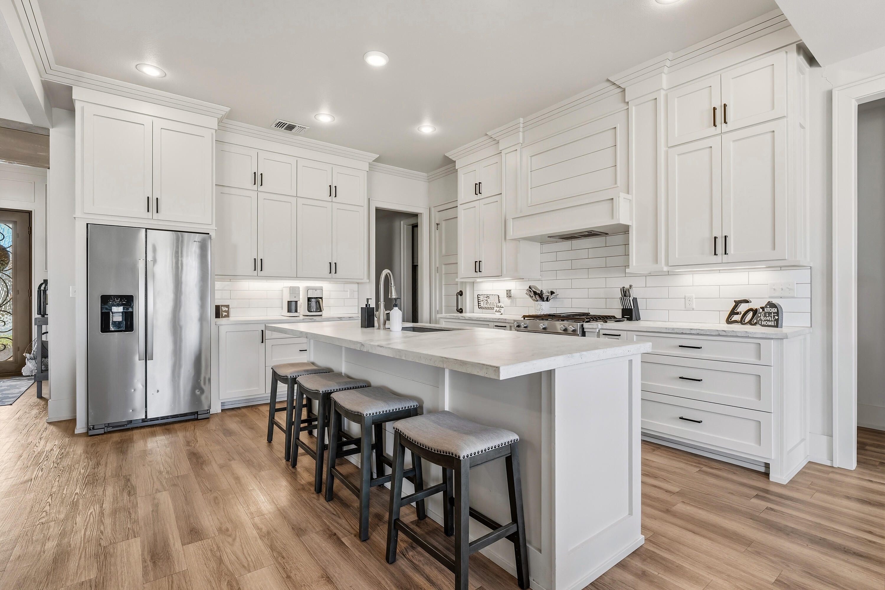 1113 16th Street Shallowater, TX 79363 - Photo 13 of 33 a kitchen with stainless steel appliances granite countertop a white cabinets and wooden floor