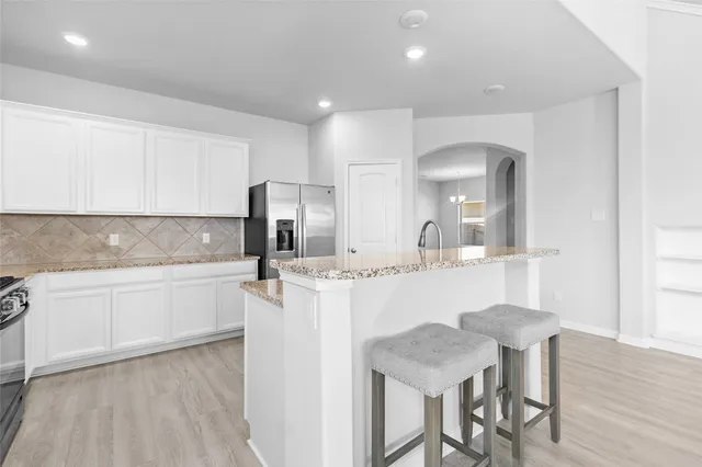 a kitchen with a sink cabinets and wooden floor