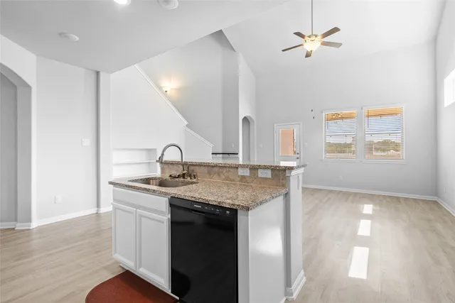 a kitchen with a sink a chandelier and wooden floor