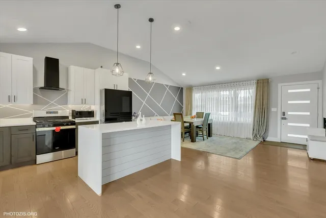 a kitchen with kitchen island granite countertop a sink appliances and cabinets