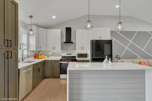 a kitchen with stainless steel appliances kitchen island granite countertop a refrigerator a stove and a sink with wooden floor