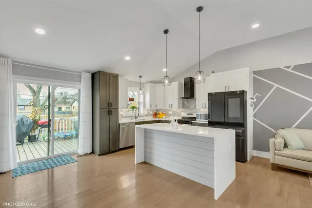 a kitchen with stainless steel appliances kitchen island granite countertop a refrigerator and microwave