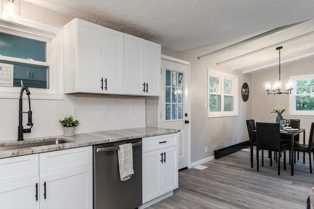 a kitchen with stainless steel appliances granite countertop a white cabinets and a stove top oven