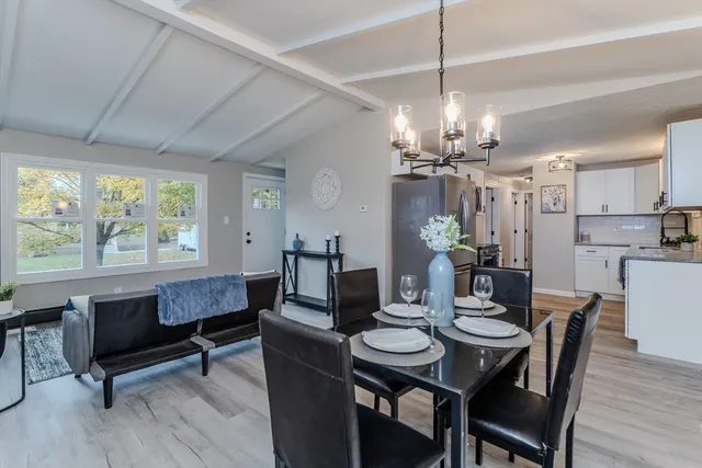 a view of a dining room with furniture a chandelier and wooden floor