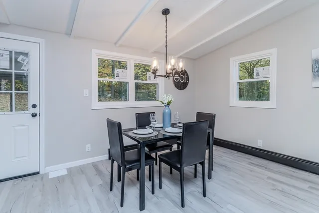 a view of a dining room with furniture a chandelier and wooden floor