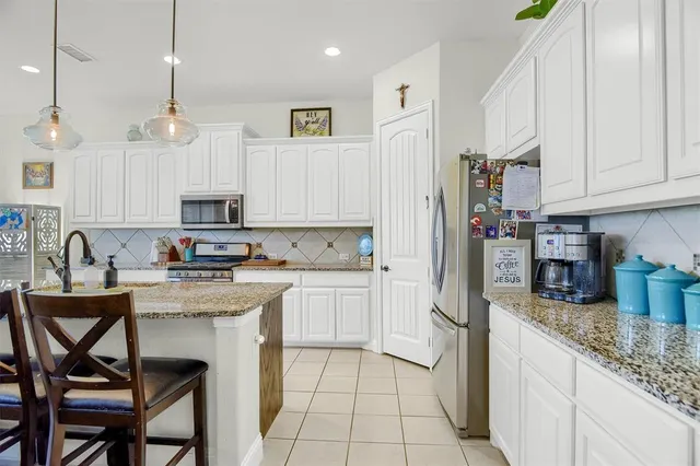 a kitchen with granite countertop a sink appliances cabinets and furniture