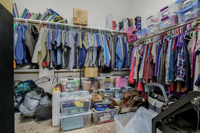 a view of walk in closet with clothes and shoes