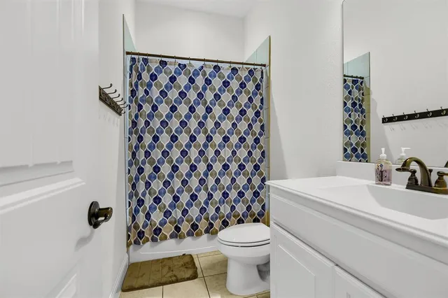 a bathroom with a sink a toilet and a shower curtain