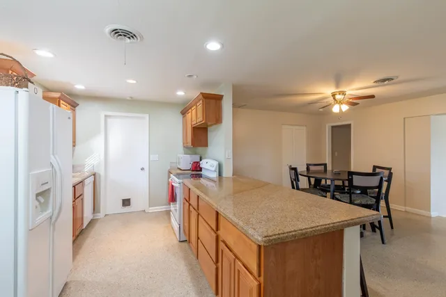 a kitchen with stainless steel appliances granite countertop a sink a refrigerator and a stove