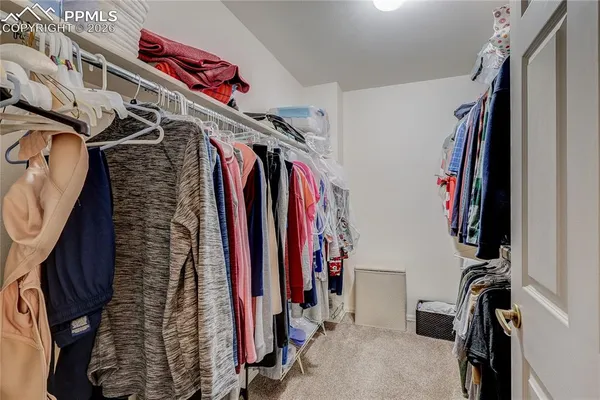 a view of walk in closet with clothes