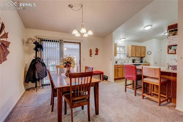 a view of a dining room with furniture and chandelier