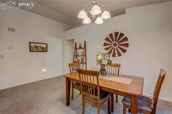 a view of a dining room with furniture and chandelier