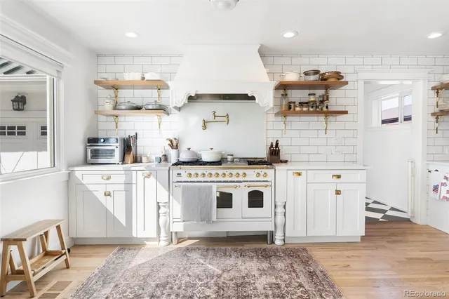 a kitchen with stainless steel appliances granite countertop a stove a sink and a refrigerator