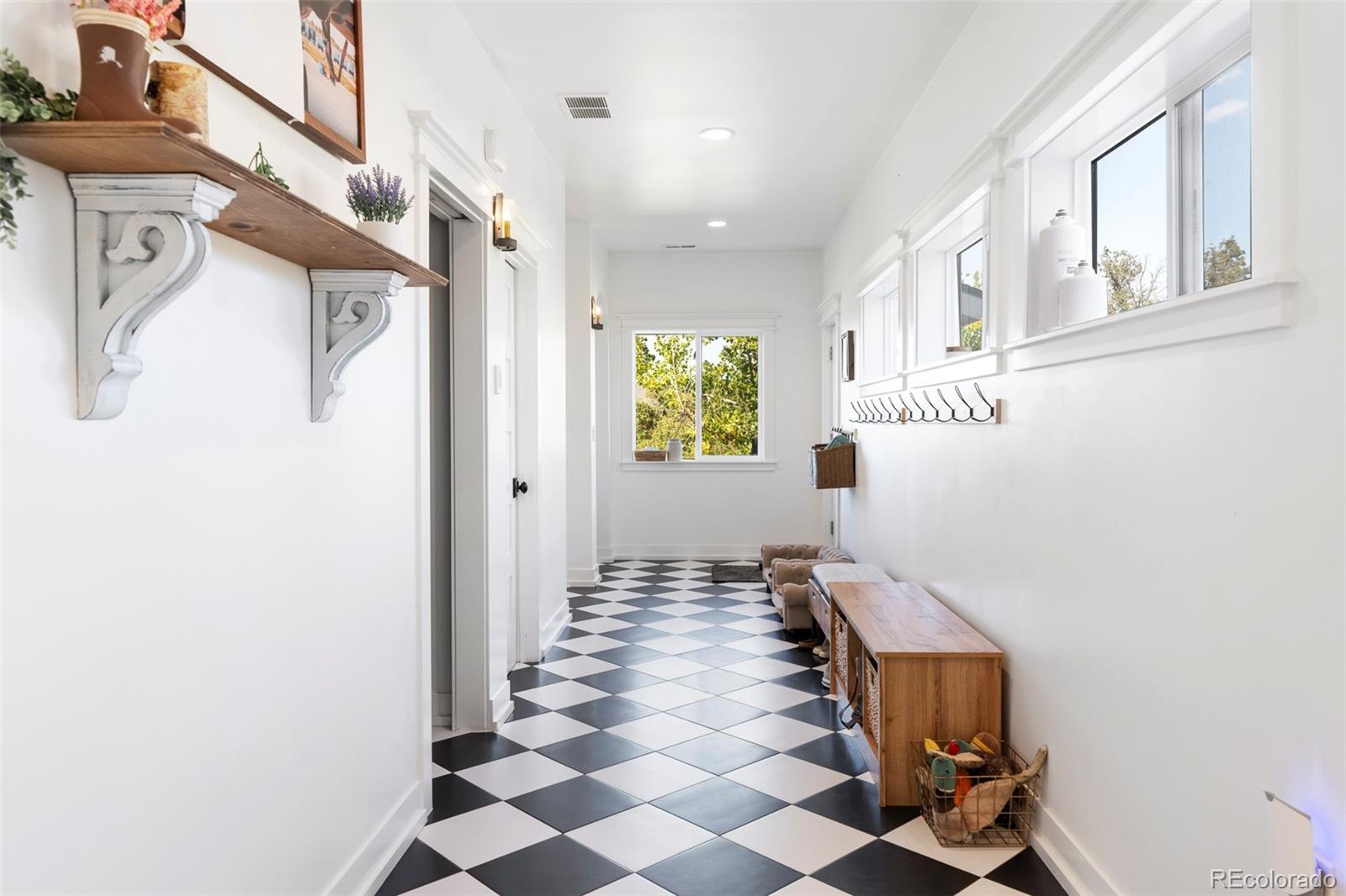2073 South Perry Park Road Sedalia, CO 80135 - Photo 16 of 41 a view of a hallway with windows and chandelier