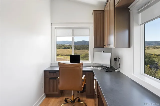a view of workspace with wooden floor windows