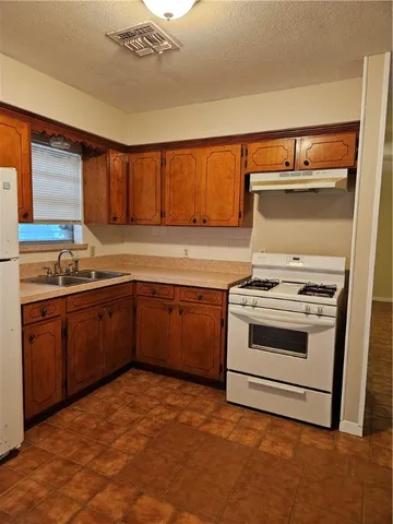 a kitchen with a stove a sink and a microwave