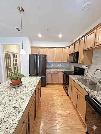 a kitchen with kitchen island granite countertop a stove a refrigerator a sink dishwasher with a dining table and chairs