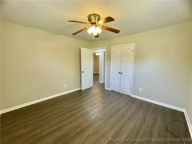 a view of an empty room with a chandelier fan