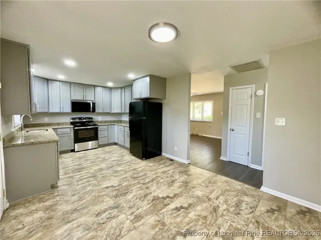a kitchen with stainless steel appliances granite countertop a refrigerator and a sink