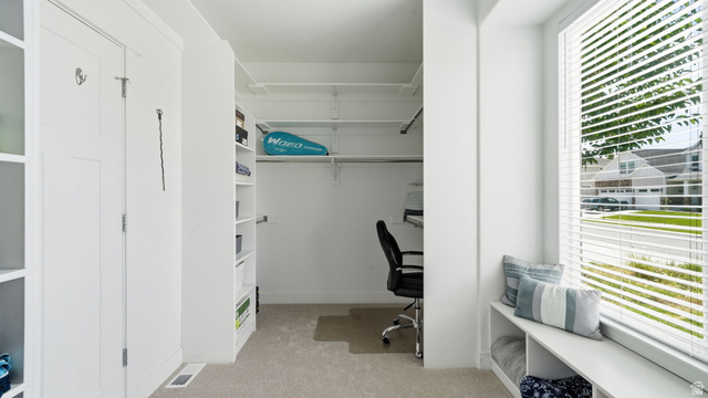 111 East Silver Oak Road Vineyard, UT 84059 - Photo 21 of 50 White built-in cabinetry and shelving, recessed closet space with adjustable shelving, window seating with integrated storage, large window with horizontal blinds, and carpeted flooring