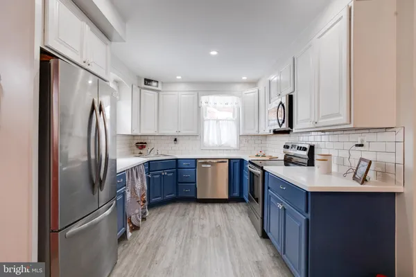 a kitchen with stainless steel appliances granite countertop a refrigerator sink and wooden cabinets