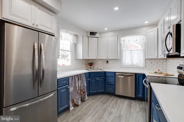 a kitchen with stainless steel appliances a stove sink microwave and cabinets