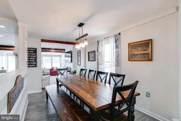 a view of a dining room and livingroom with furniture wooden floor a chandelier