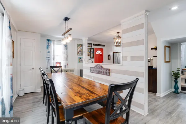 a dining room with furniture a chandelier and wooden floor