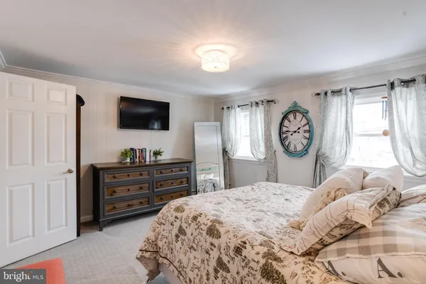 a spacious bedroom with a bed and a chandelier