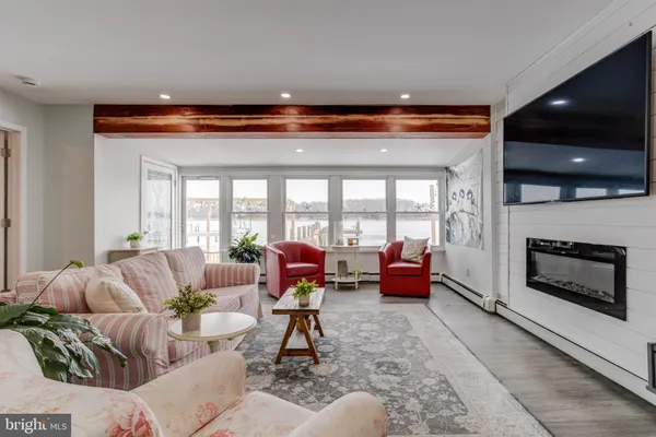 a living room with furniture fireplace and a large window