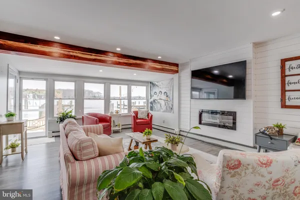 a living room with furniture flat screen tv and a large window