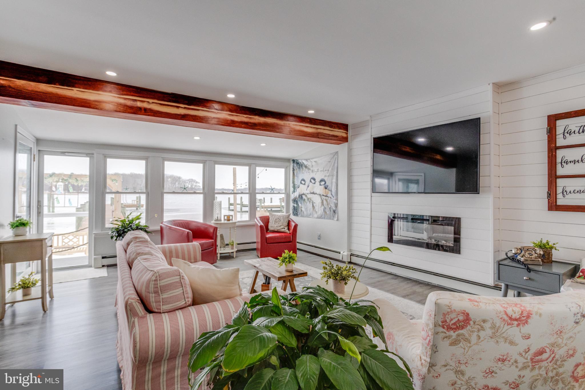 1815 Wilson Point Road Middle River, MD 21220 - Photo 6 of 76 a living room with furniture a flat screen tv and floor to ceiling windows