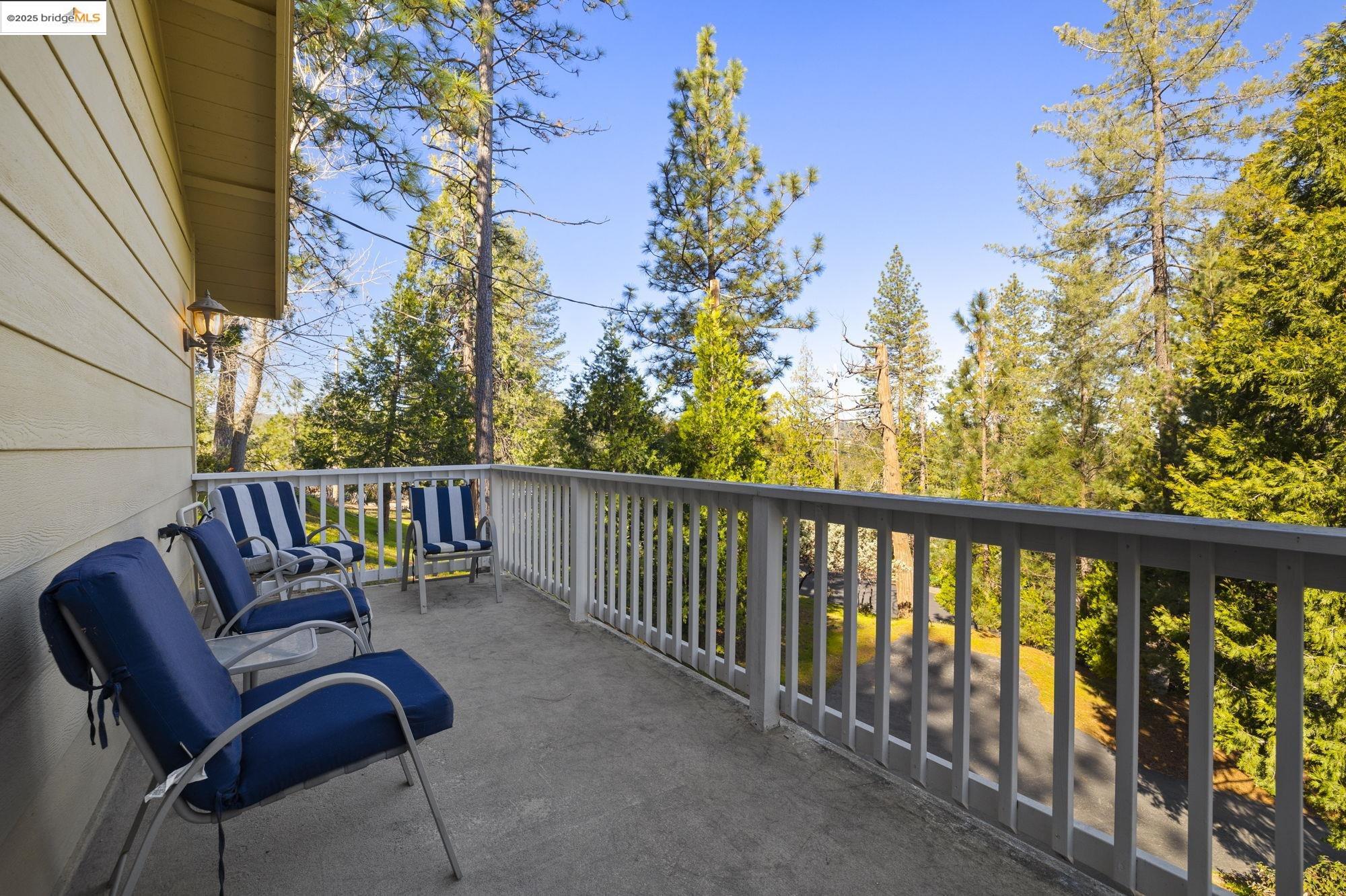 12080 Breckenridge Road Groveland, CA 95321 - Photo 24 of 48 a balcony with wooden floor table and chairs