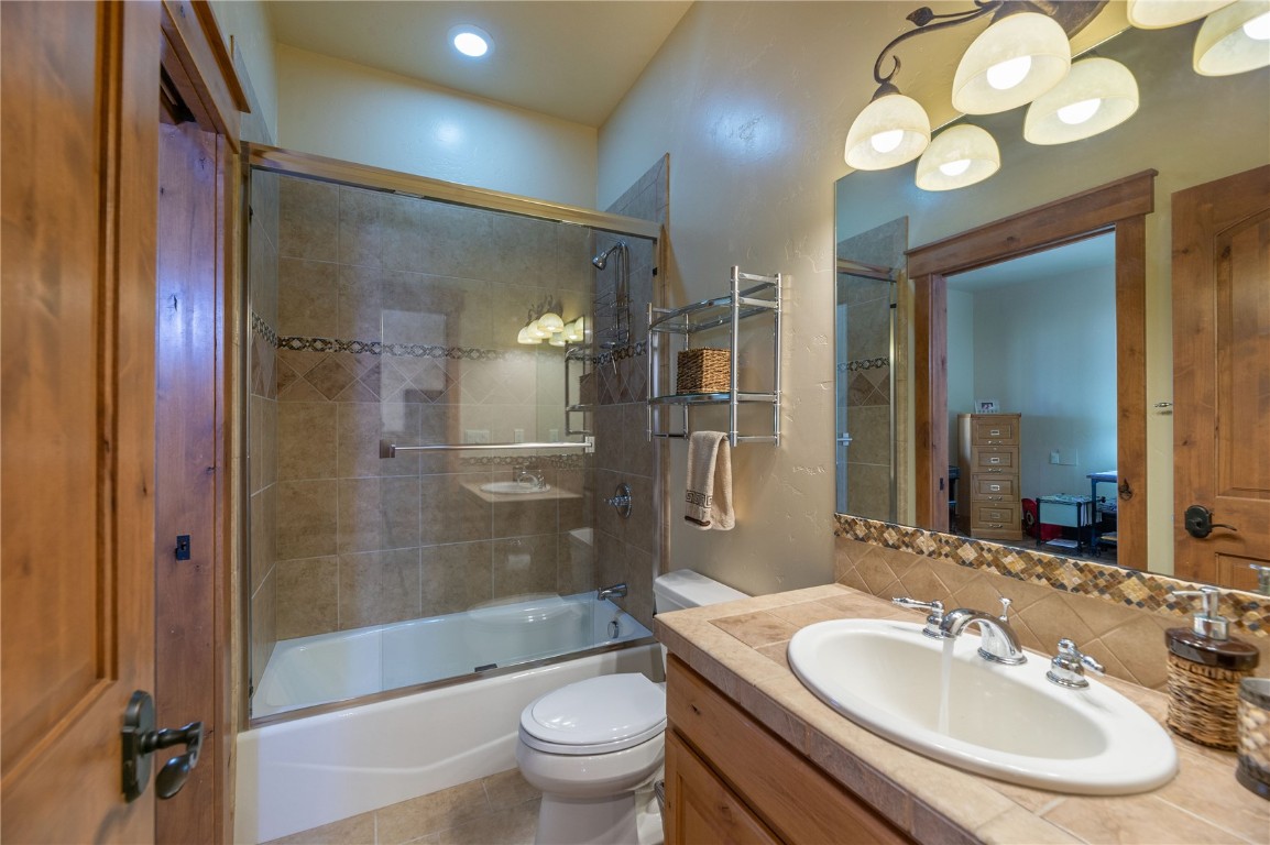 2206 Hamilton Creek Road Silverthorne, CO 80498 - Photo 25 of 39 Full bathroom with tasteful backsplash, toilet, enclosed tub / shower combo, vanity, and tile patterned flooring