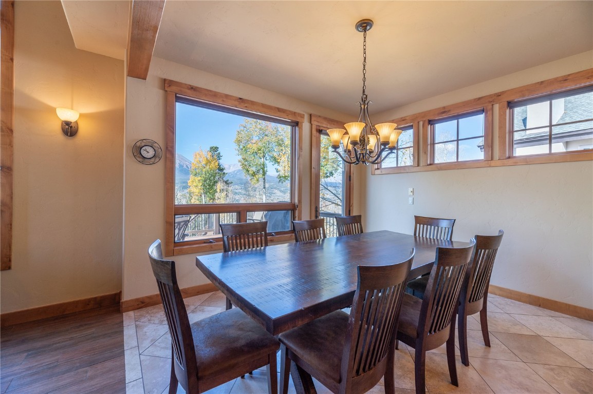 2206 Hamilton Creek Road Silverthorne, CO 80498 - Photo 30 of 39 Dining space featuring beam ceiling, a chandelier, and hardwood / wood-style flooring