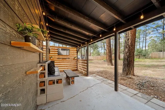 a view of a porch with a table and chairs and floor to ceiling window