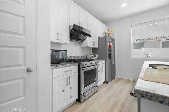 a kitchen with stainless steel appliances granite countertop a stove a sink and a refrigerator