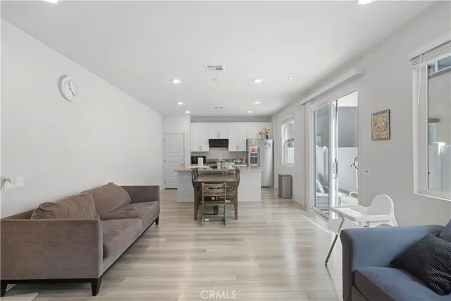 a living room with furniture and view of kitchen