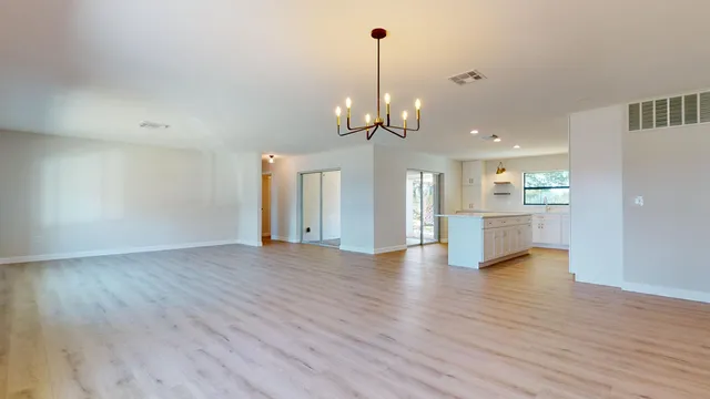 a large kitchen with a lot of counter space and wooden floor